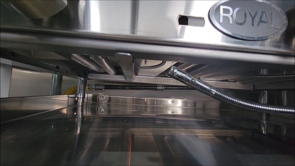 under-griddle view showing braided gas line to pilot orifice