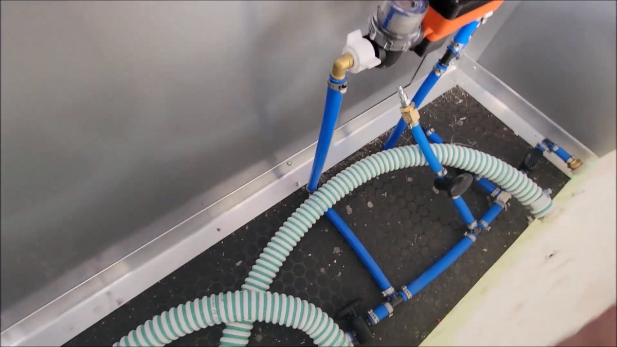 riser hatch plumbing showing tank knobs, drain, and air nozzle